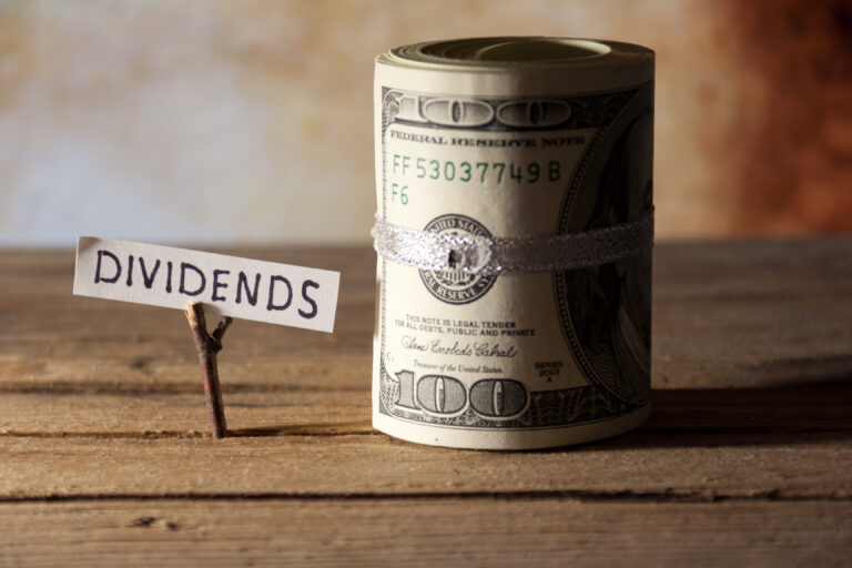 21 05 25 a sign with the word dividends next to a money roll gettyimages 186201544