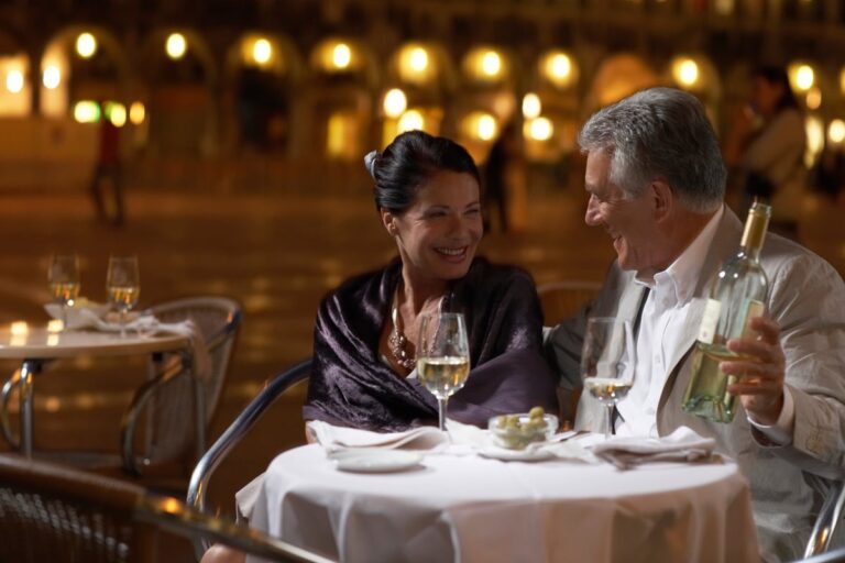 Well dressed mature couple enjoying wine with a fancy meal 4jxssXd