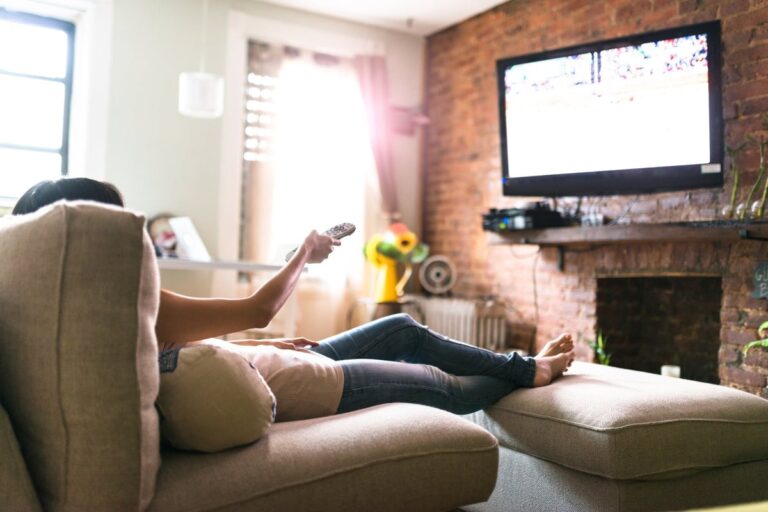 Woman lounging on her sofa watching tv 5hUj7jx