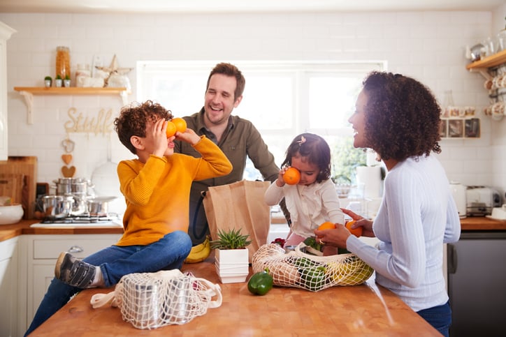 family unpacking groceries in kitchen