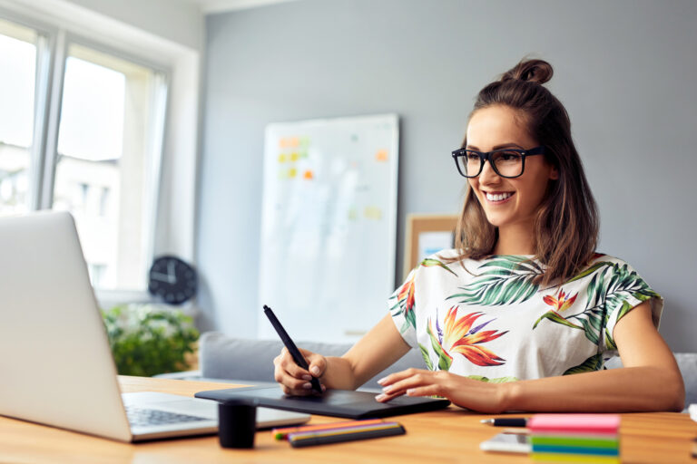 graphic designer smiling at laptop