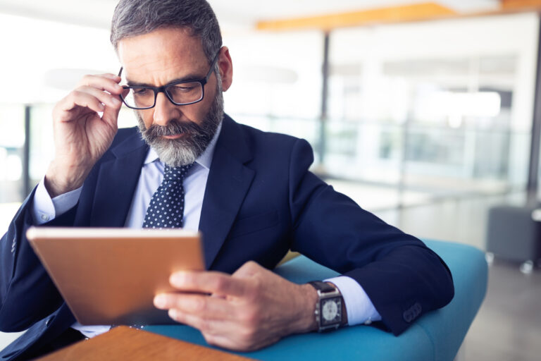 investor in business attire reviews information on a tablet