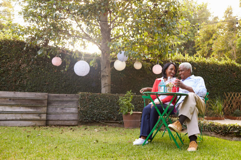 mature couple relaxing drinking wine together in their backyard