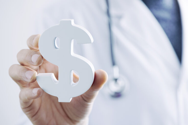 medical professional holding dollar sign paperweight