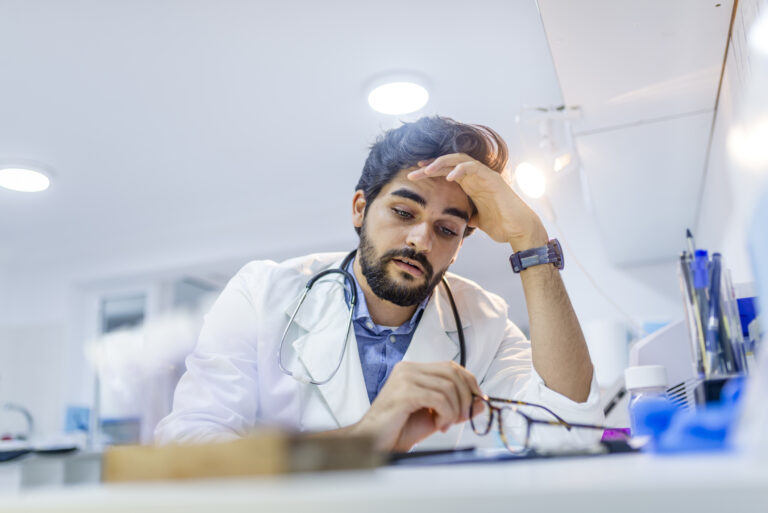 medical professional with hand on head