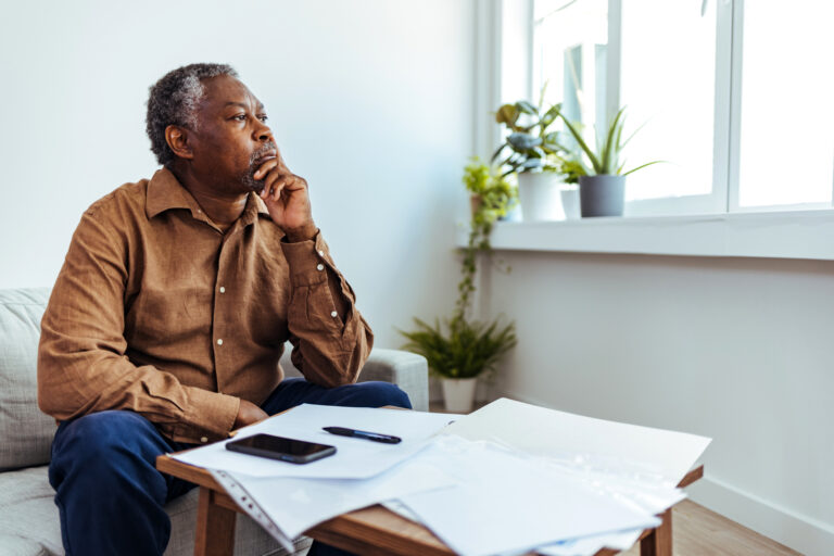 person with a serious expression looking out a window