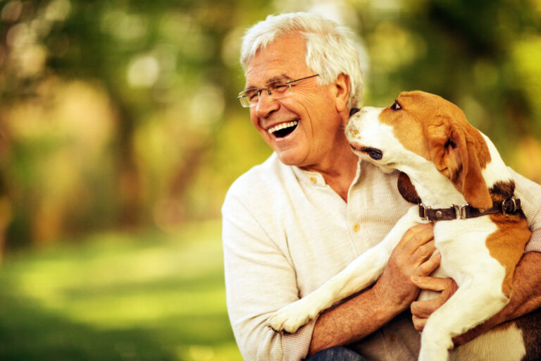 senior man smiling being licked by dog gettyimages 500725657