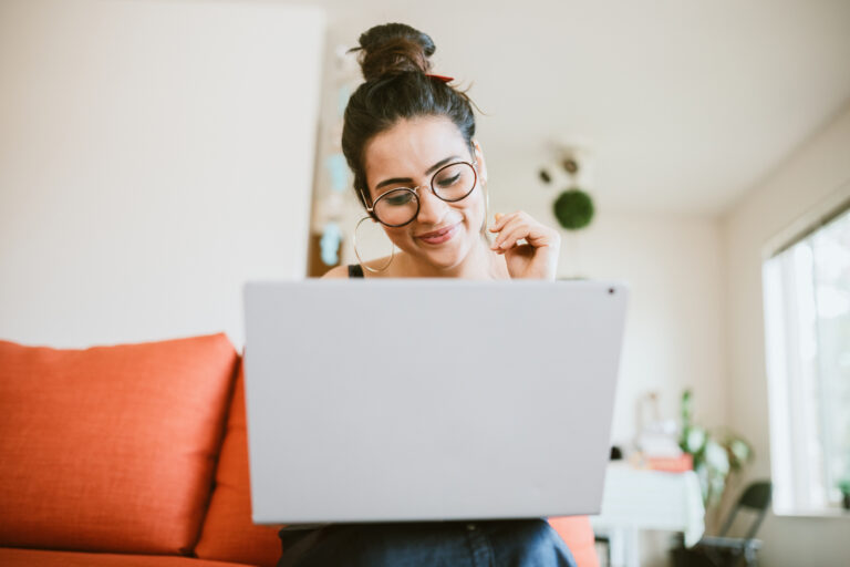 smiling person looking at laptop