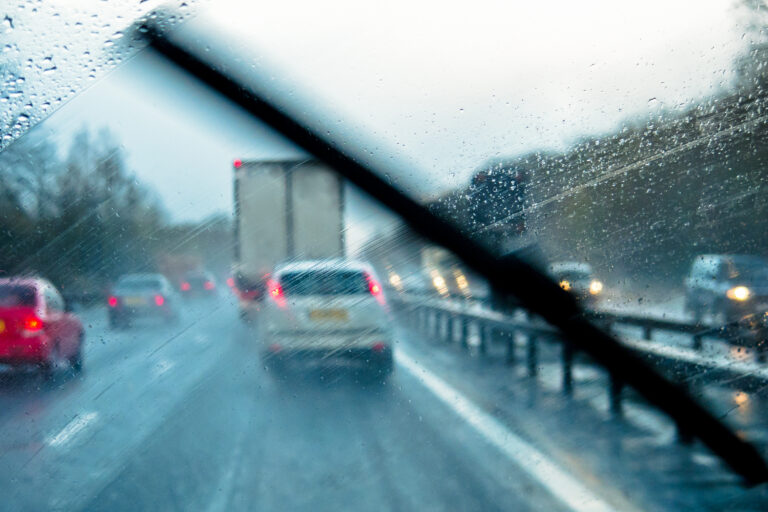 view behind windshield of a highway on a rainy day