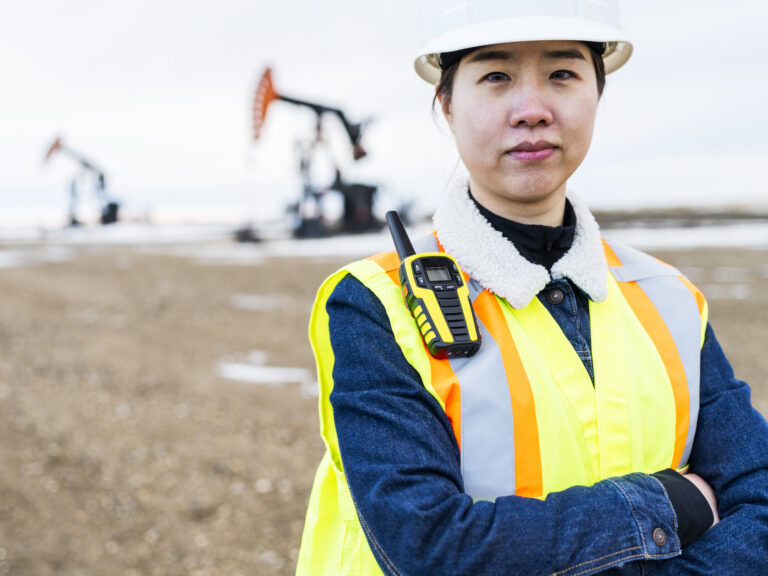 21 05 18 a person in protective gear with oil wells in the background gettyimages 1210681471