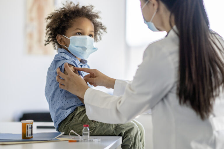 child receiving a vaccination shot from a healthcare professional