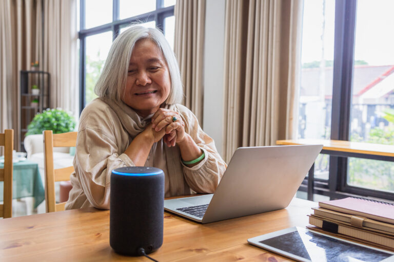 older person sitting at a desk featuring a laptop