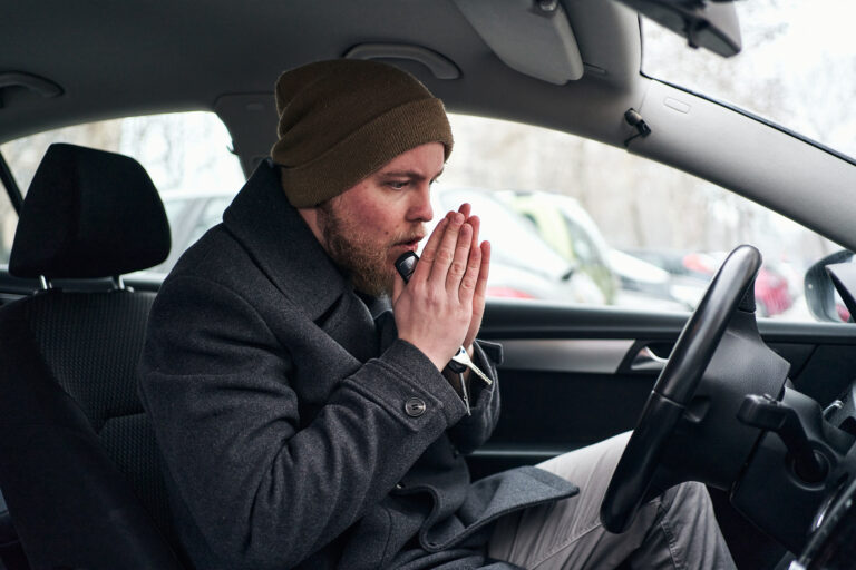 person putting hands together in the drivers seat of a car