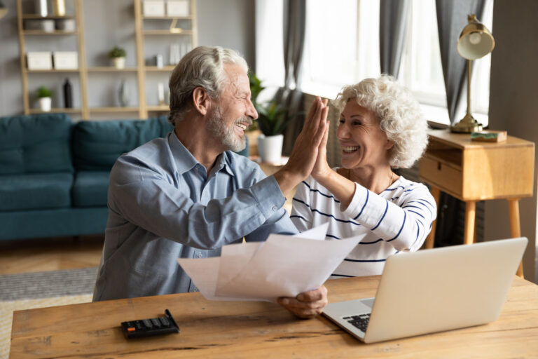 retired couple reviewing finances on a laptop