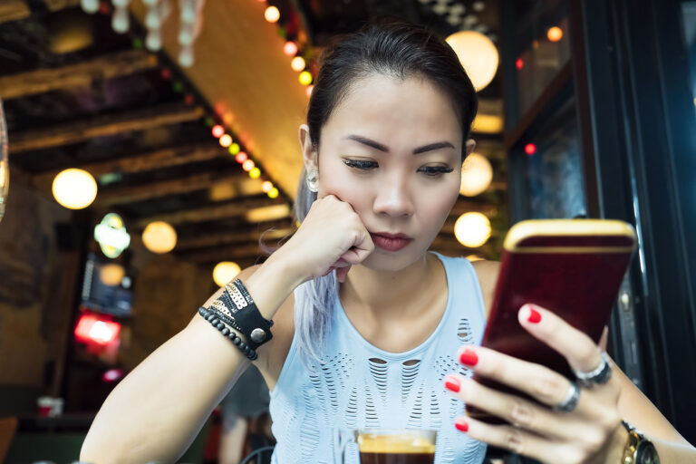 seated young person gazing at a smartphone