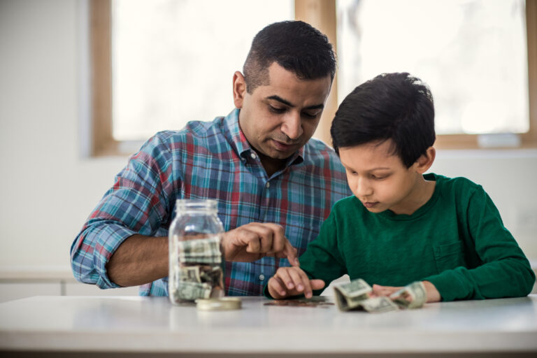 two people counting money on a table