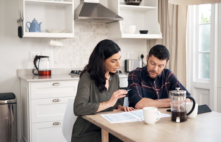 couple talking over papers in kitchen KRXu4bp