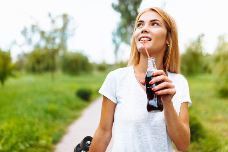 person drinking bottled drink with a straw