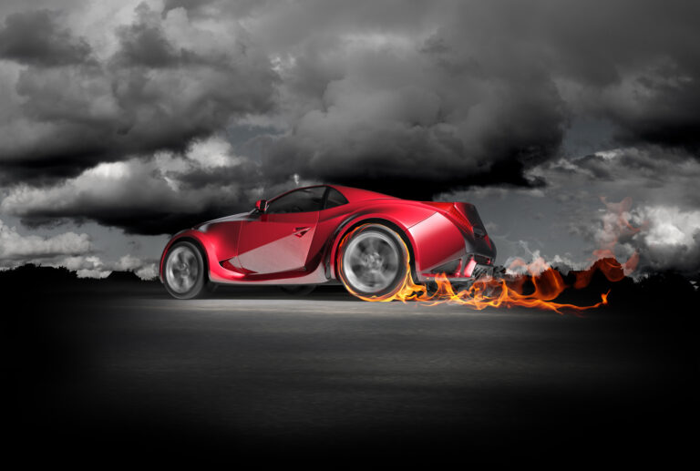 futuristic red sports car burning up the track with flames at wheels under a black and white sky