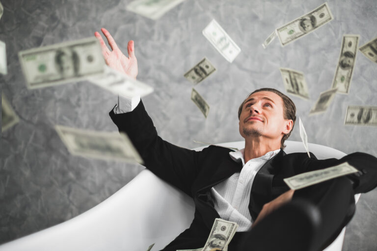 man sitting flying currency notes