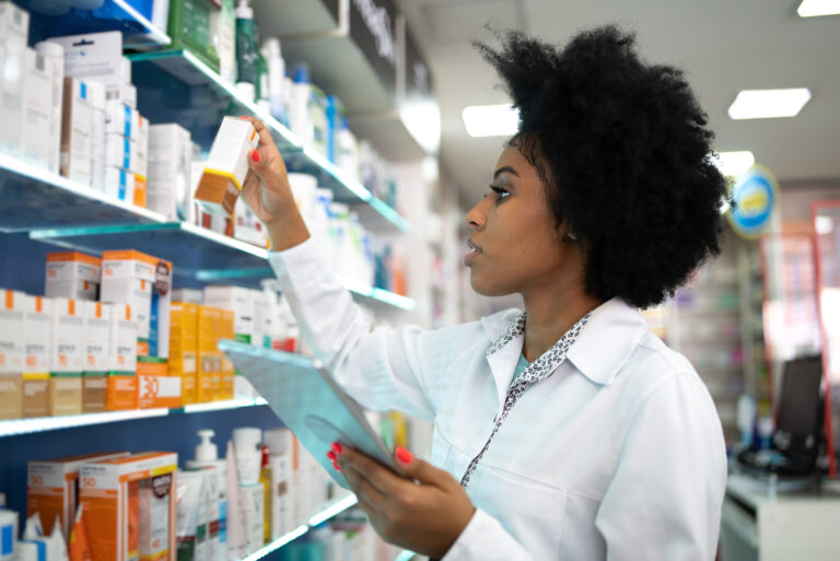 person checking medicine on a shelf in a pharmacy