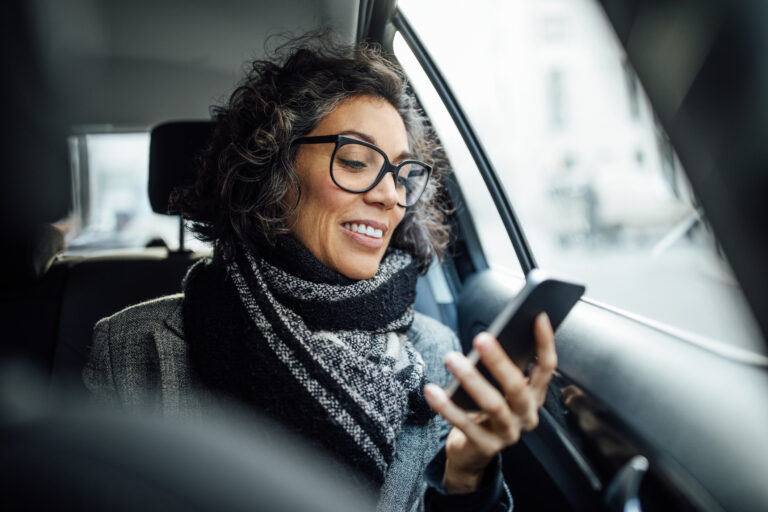 person sitting in a car looking at a phone