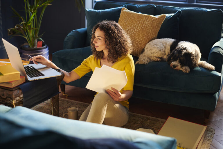 person sitting on the floor looking at a laptop