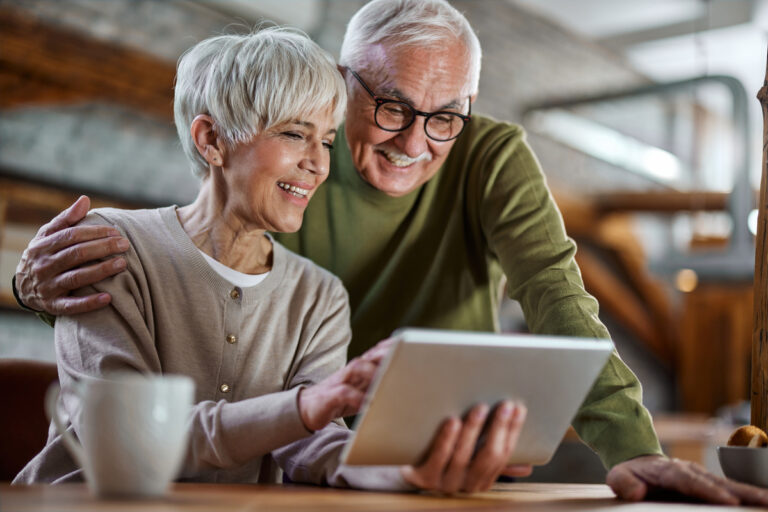 smiling couple looking at tablet together