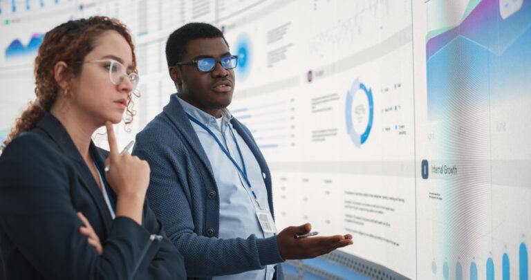 two people looking at a screen with data