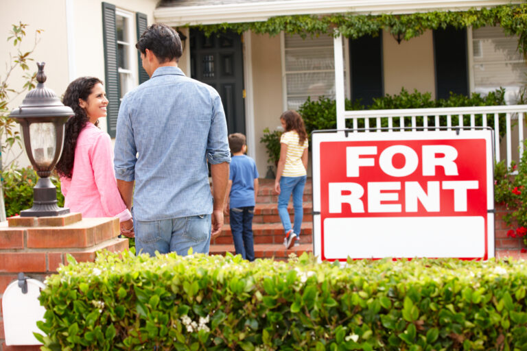 people outside a single family home with a for rent sign