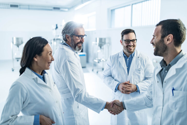scientists smiling and shaking hands