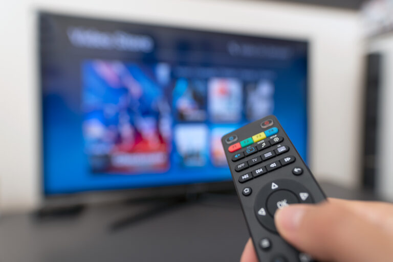 tv remote points at blurred screen 1038491694