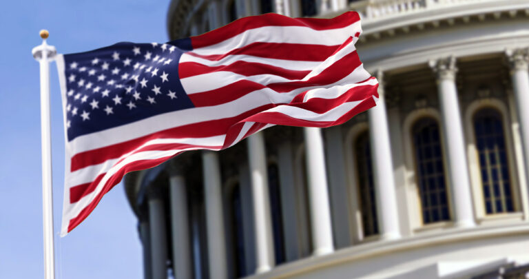 american flag in front of capital building