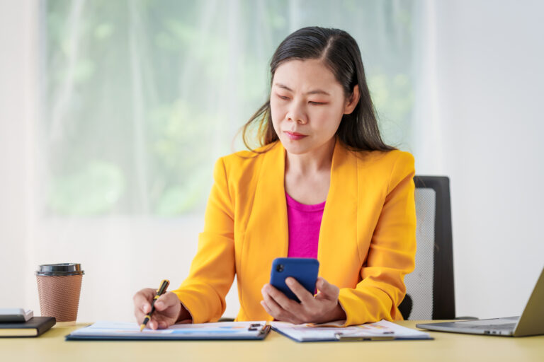 investor at desk considers phone and papers